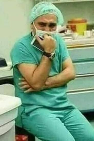 Surgeon in distress and a newborn lying on a mother who passed away during childbirth.
