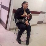 Policewoman in uniform breastfeeding an abandoned baby in a hospital corridor.