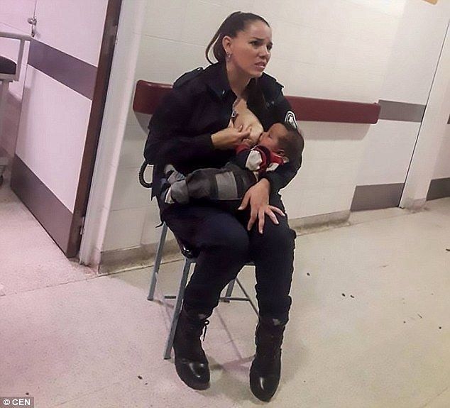 Policewoman in uniform breastfeeding an abandoned baby in a hospital corridor.