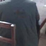 Man sitting alone at a restaurant table, seen from behind.